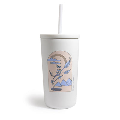 White tumbler with straw with pink and blue coffee plant, mountains, and clouds design.