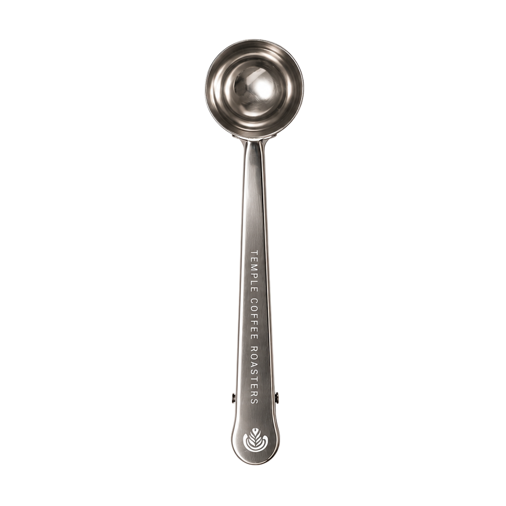 A stainless steel measuring scoop with a long handle, featuring the text 'TEMPLE COFFEE ROASTERS' and a logo engraved on the side, set against a plain white background.