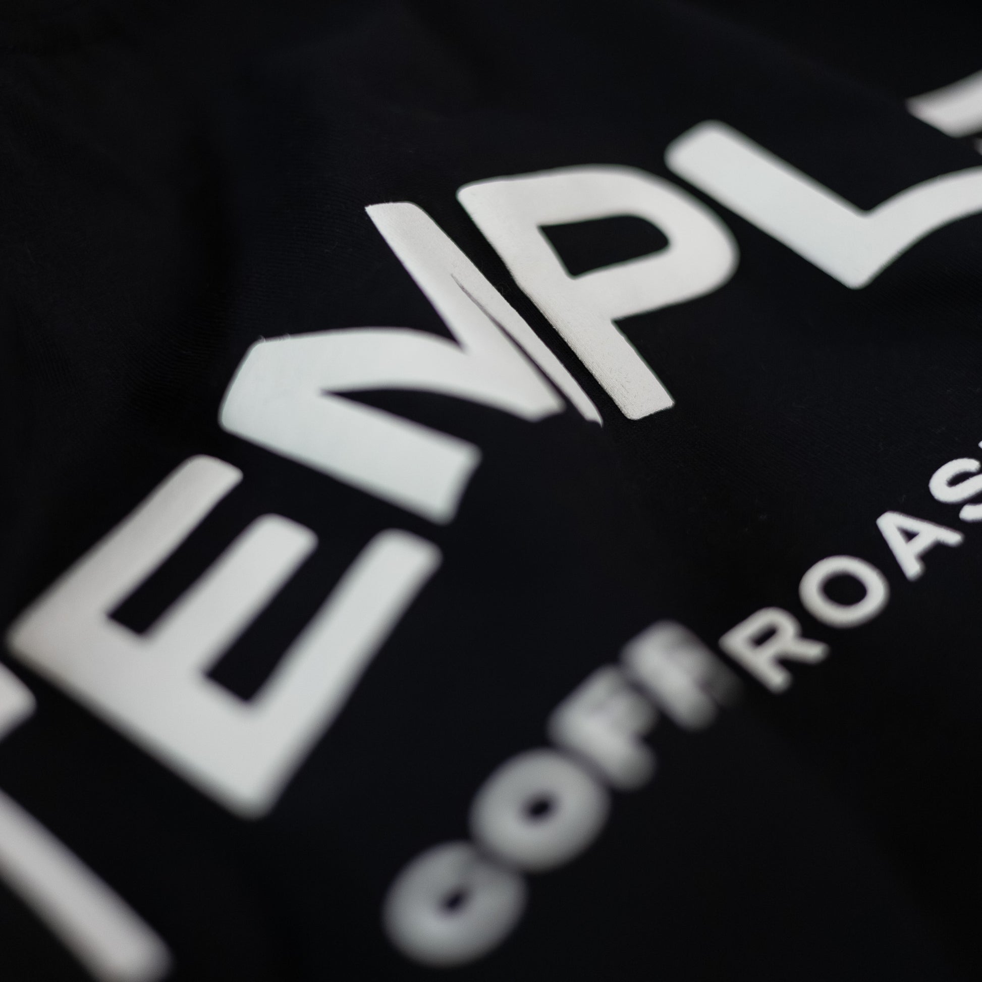 Close-up of a black t-shirt with white text on a dark background