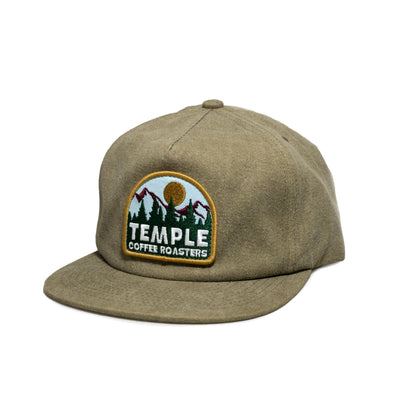 Olive green hat with a Temple Coffee Roasters embroidered patch featuring mountains, trees, and a sun.