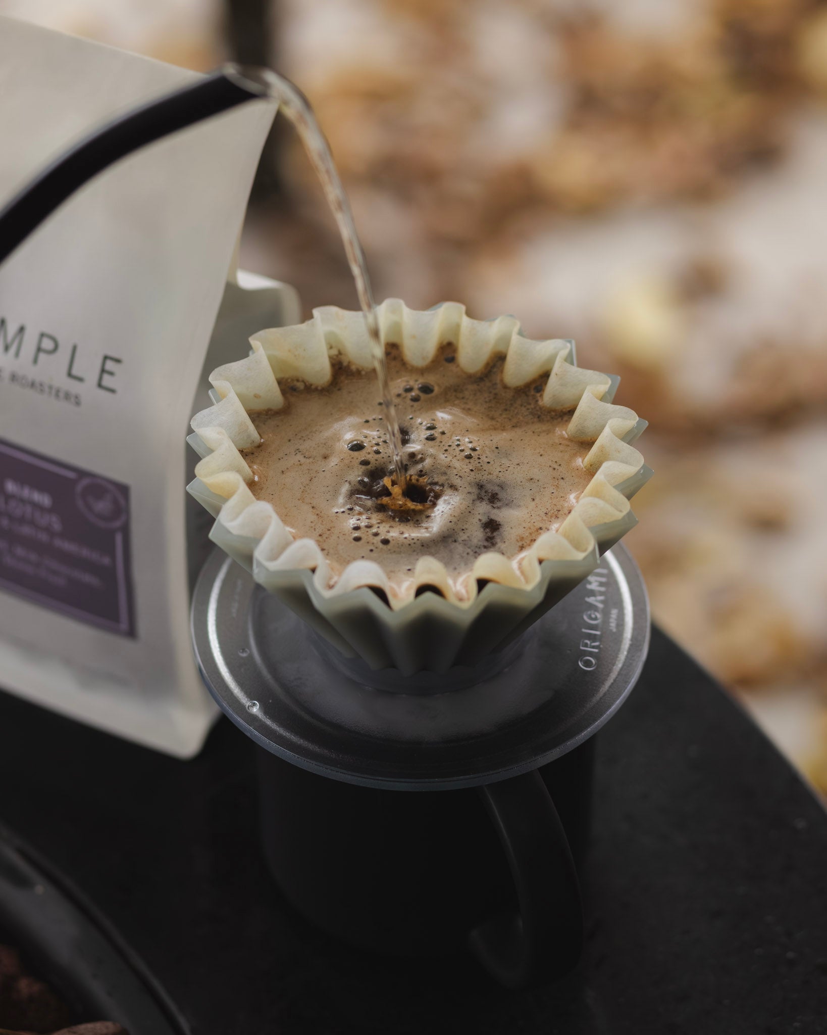 Coffee being poured into a Origami Dripper with a blurred background