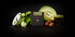 Box of coffee surrounded by fruits and flowers.