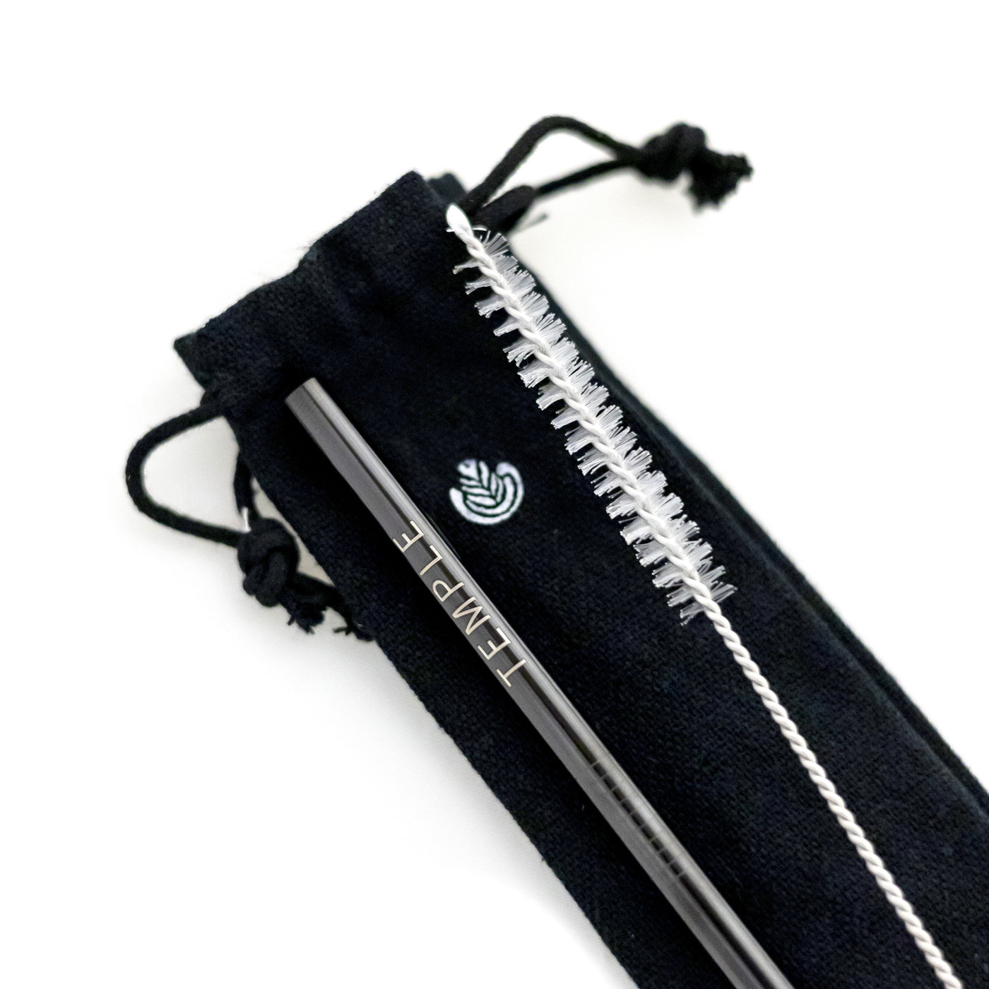 Closeup of black metal straw engraved with the 'Temple' logo, accompanied by a straw-cleaning tool, resting on a black fabric carrying case featuring the Rosetta logo.