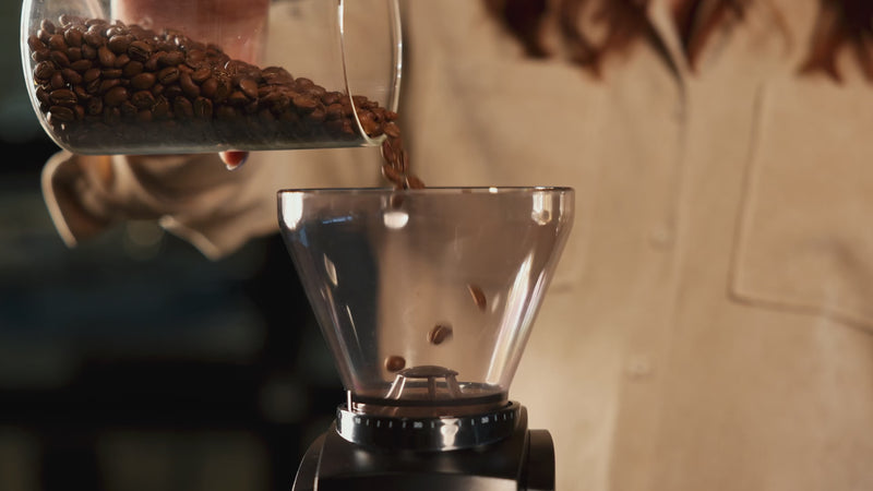 Pour-over coffee being made: beans to grinder, grounds to filter, coffee in Chemex.